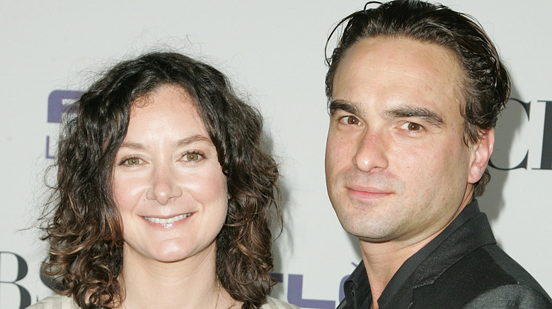 Sara Gilbert and Johnny Galecki posing on step-and-repeat