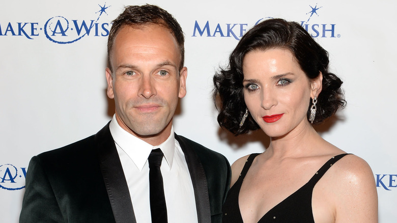 Jonny Lee Miller and Michele Hicks smile