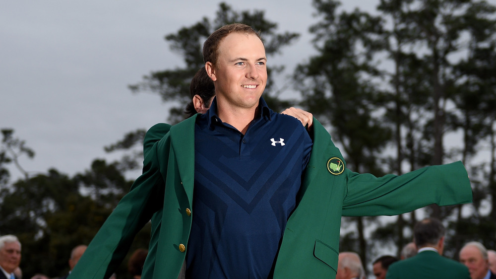 Jordan Spieth putting on his green Masters jacket