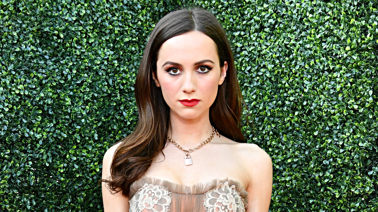 Maude Apatow in front of bushes