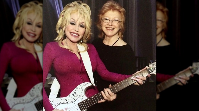 Dolly Parton with her best friend, Judy Ogle, holding a guitar.