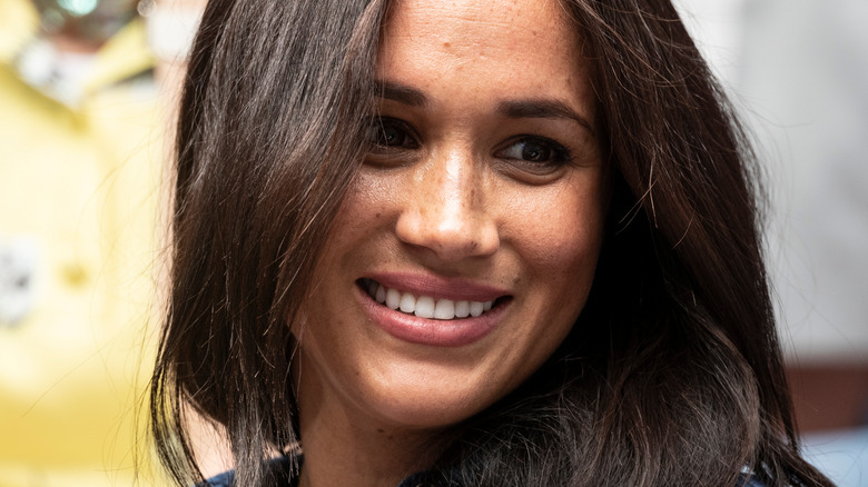 Meghan Markle smiling looking to the side