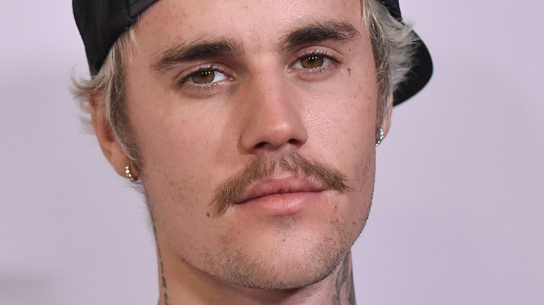 Justin Bieber poses with black cap.