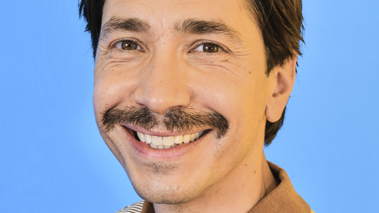 Smiling Justin Long with mustache