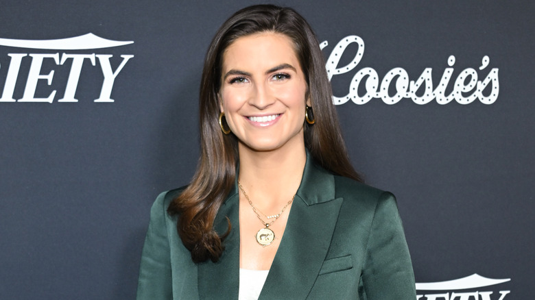 Kaitlan Collins smiling in a green suit.