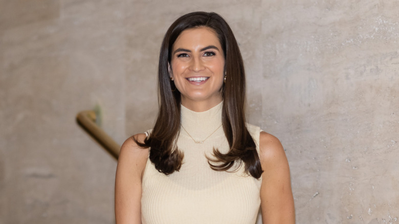 Kaitlan Collins smiling while posing on stairs