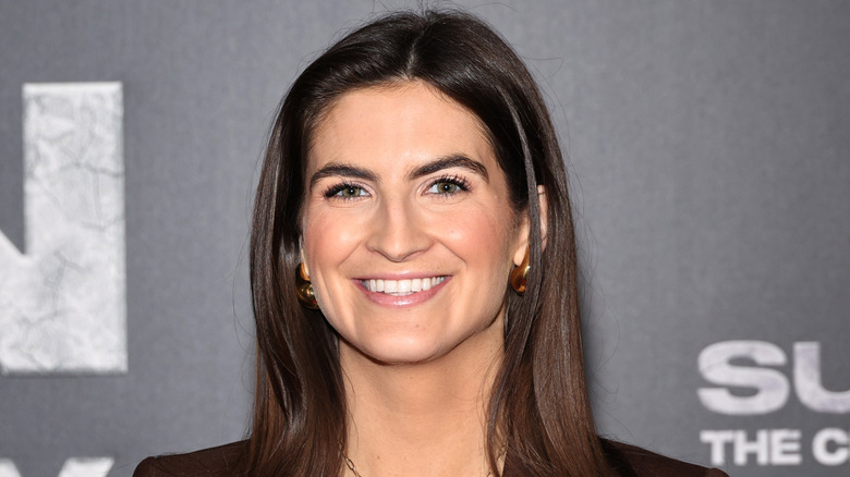 Kaitlan Collins smiling in a brown suit while at the premiere of 