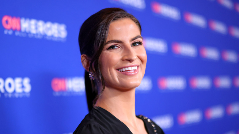 Kaitlan Collins smiling in a black shirt.