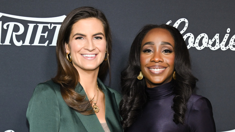Kaitlan Collins and Abby Phillip smiling and wearing gold earrings.