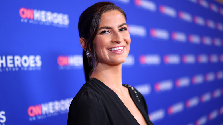 Kaitlan Collins smiling while posing on the red carpet in black