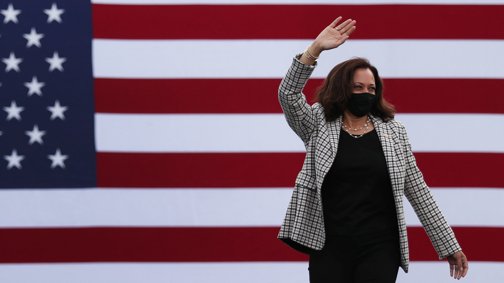 Kamala Harris waving at the crowd during a campaign stop
