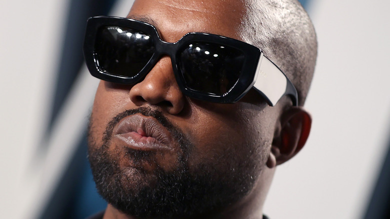 Ye wears shades and grimaces