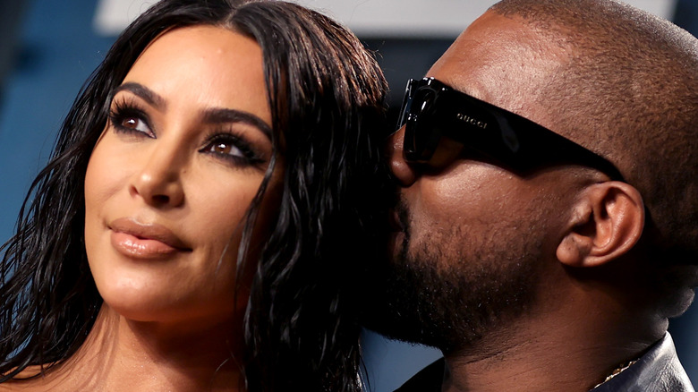 Kanye West whispering to Kim Kardashian