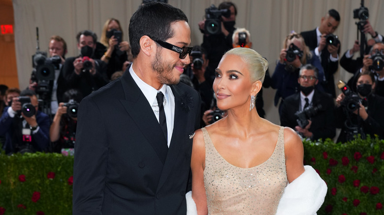 Kim Kardashian and Pete Davidson smile at each other in front of photographers