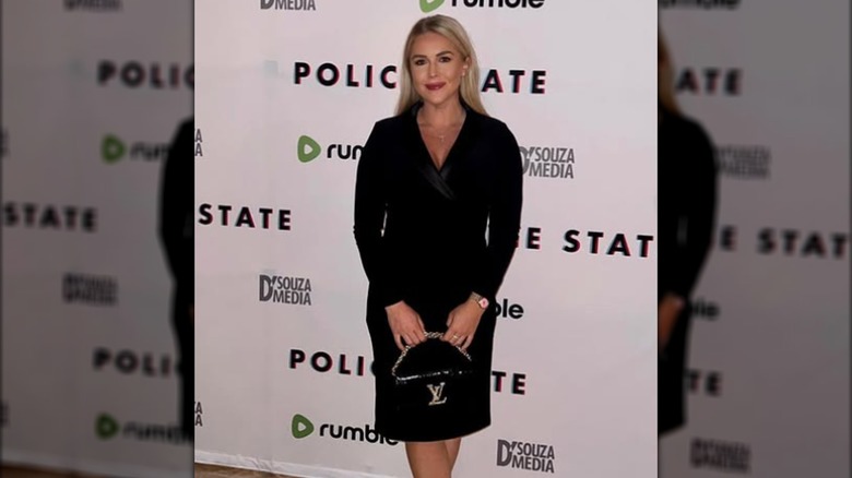 Karoline Leavitt posing at a film premiere in a black dress