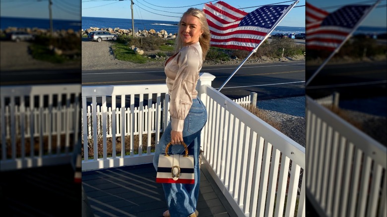 Karoline Leavitt posing in front of an American flag.