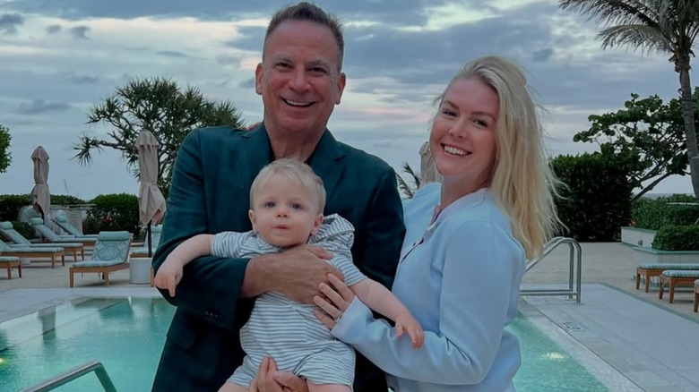 Karoline Leavitt poses beside a pool with Nicholas Riccio, who holds their son.
