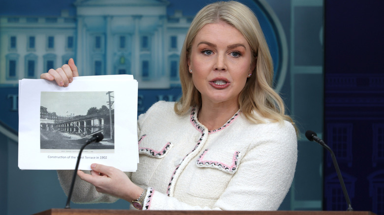 Karoline Leavitt holding up a picture of White House renovations.