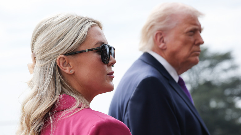 White House Press Secretary Karoline Leavitt listening as U.S. President Donald Trump answers questions from members of the press as he departs the White House
