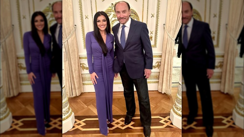 Alexis Wilkins posing with Lee Greenwood in a dusty indigo dress.