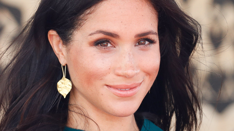 Meghan Markle poses in a green outfit.