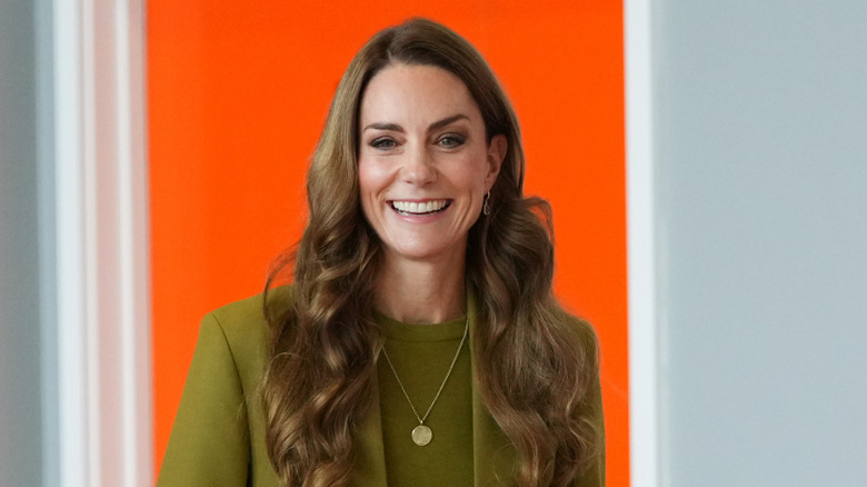 Kate Middleton smiling wearing green suit