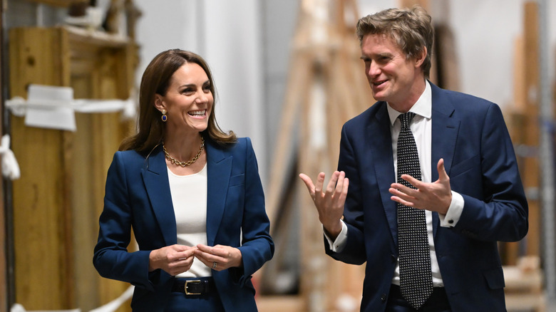 Kate Middleton smiling and walking with a man