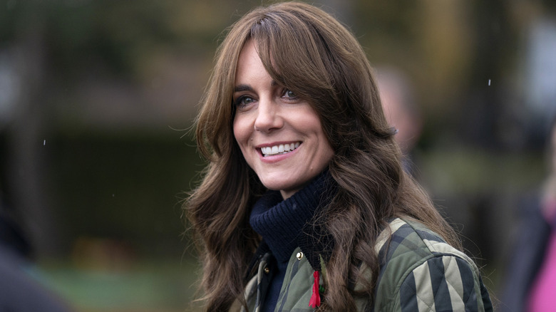 Kate Middleton smiling with curtain bangs and wavy hair