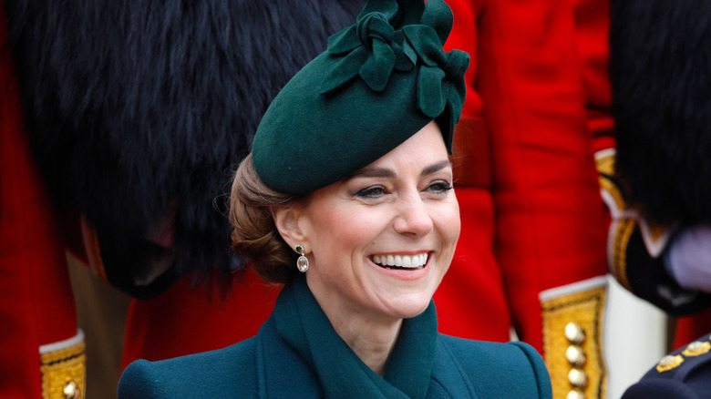 Kate Middleton smiling in green fascinator and coat
