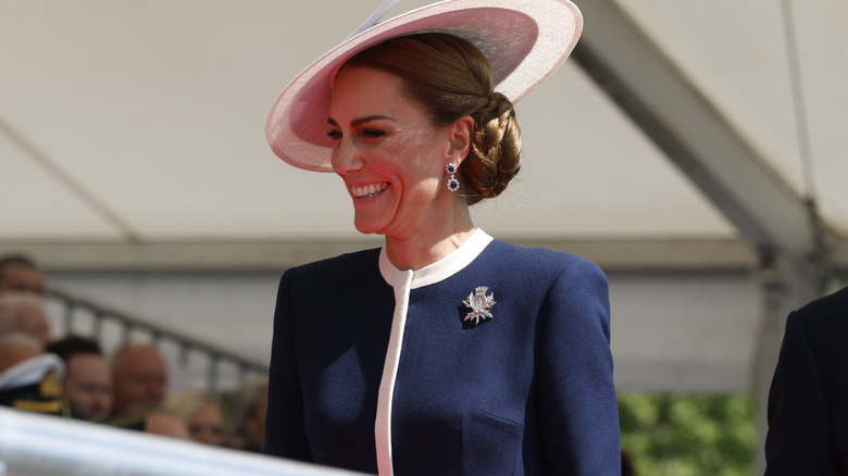Kate Middleton smiling wearing navy blue outfit