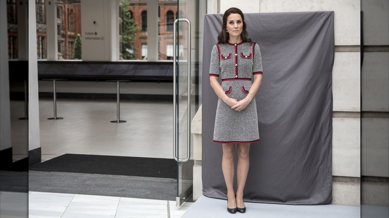 Kate Middleton posing at the V&A Museum in a Gucci dress.