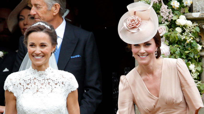 Pippa and Kate Middleton smiling at Pippa's wedding