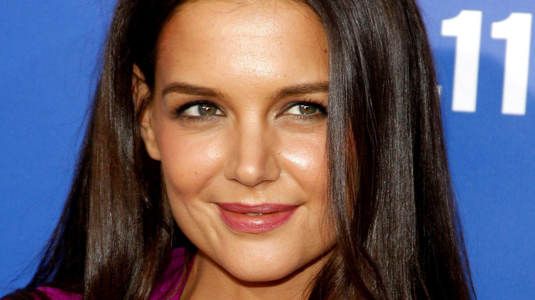 Katie Holmes in front of blue background