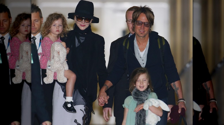 Nicole Kidman, Keith Urban holding hands while walking with daughters