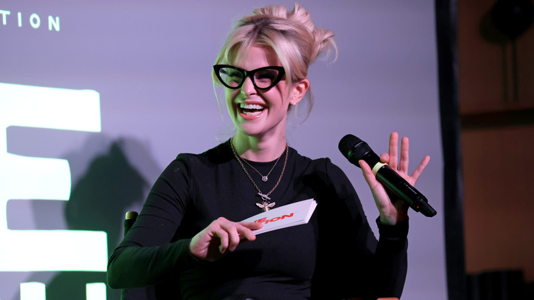 Kelly Clarkson laughs while speaking on stage.