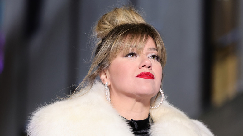 Kelly Clarkson with fierce look in red lipstick and white fur in 2023