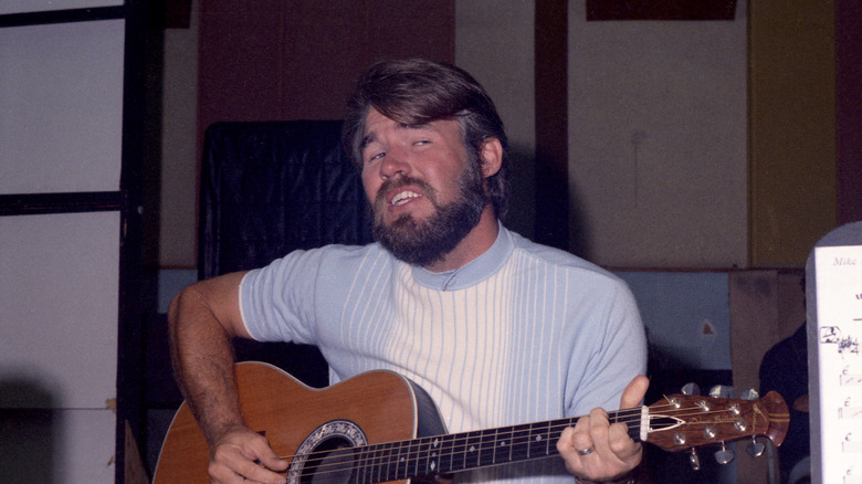 Kenny Rogers strumming a guitar in 1968