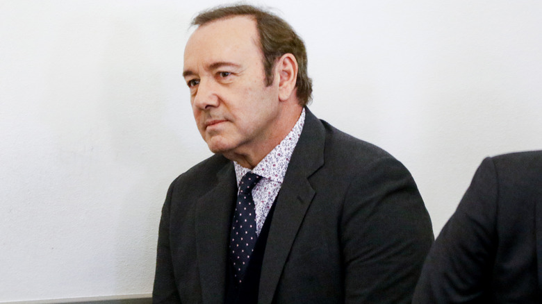 Kevin Spacey in gray suit looking glum