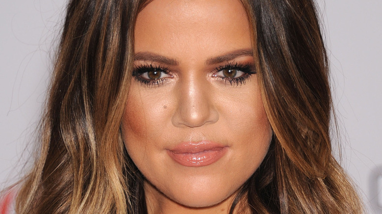 Khloe Kardashian smiles at an event