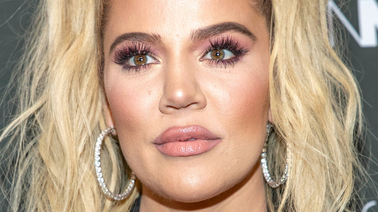 Khloe Kardashian, looking confused, 2018 photo, blond hair up in pony tail, wearing makeup