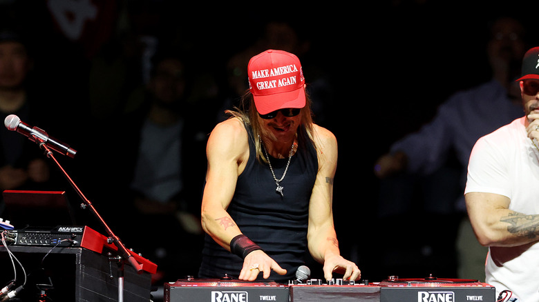 Kid Rock wearing a Make America Great Again hat while messing adjusting levels