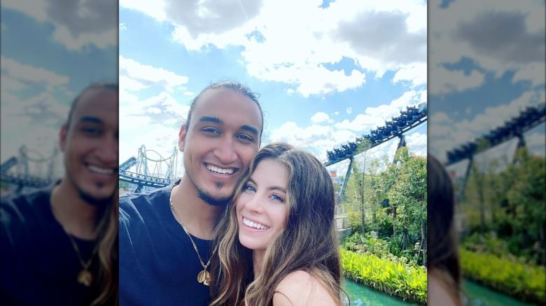 Robert James Ritchie Jr. and Marisa Trovato smiling while posing together at a theme park