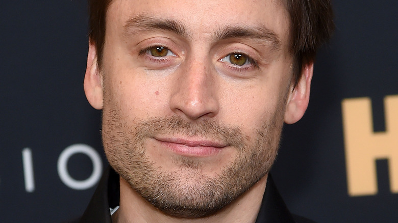 Kieran Culkin poses in a black shirt