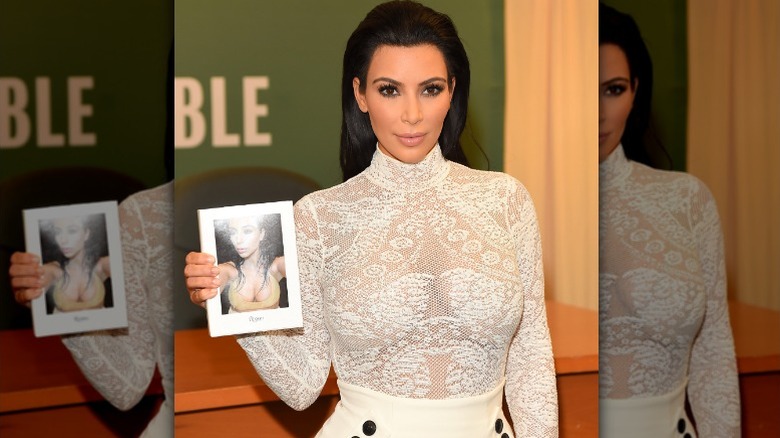Kim Kardashian holding Selfish book