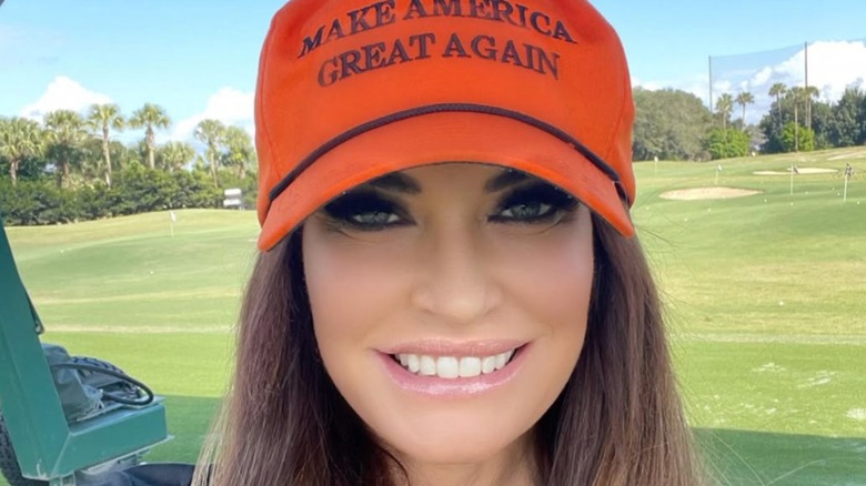 Kimberly Guilfoyle smiling in a MAGA hat.