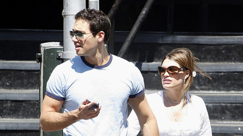 Kimberly Guilfoyle and Eric Villency outside wearing sunglasses and looking to the side.