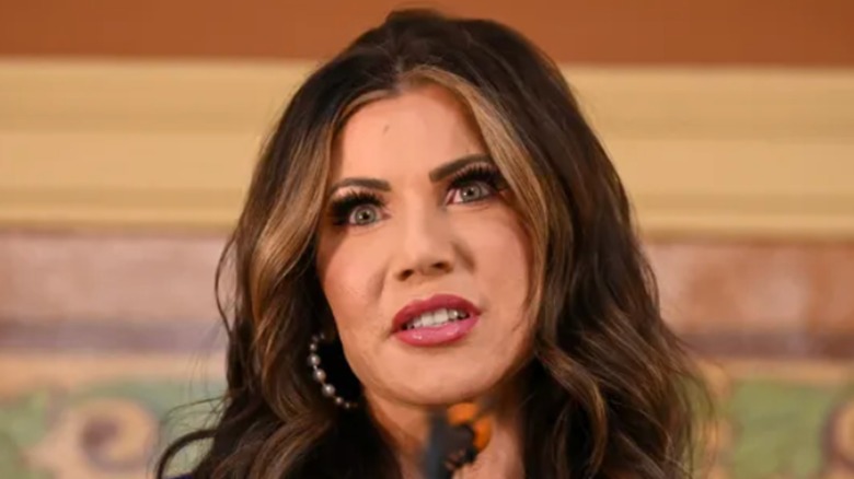Kristi Noem with wide eyes and penciled eyebrows
