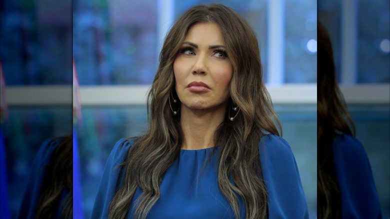 Kristi Noem glances to the side at a press conference.