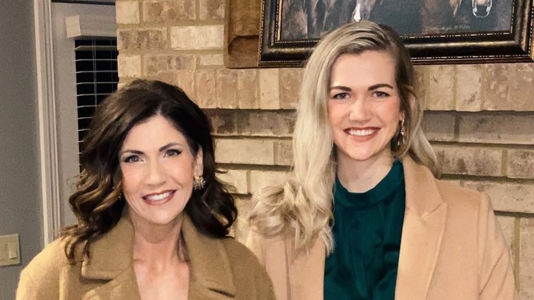 Kristi Noem smiling while posing with her daughter Kassidy in matching camel coats
