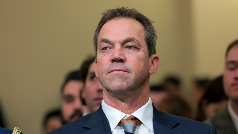 Bryon Noem pictured at a hearing in a navy suit with a white shirt